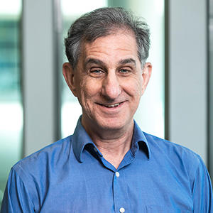 A man in a blue shirt smiles at the camera.