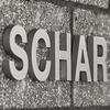 A photo of the word SCHAR on a concrete block wall.